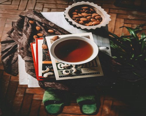 Cozy evening setup with an open book and a cup of herbal tea