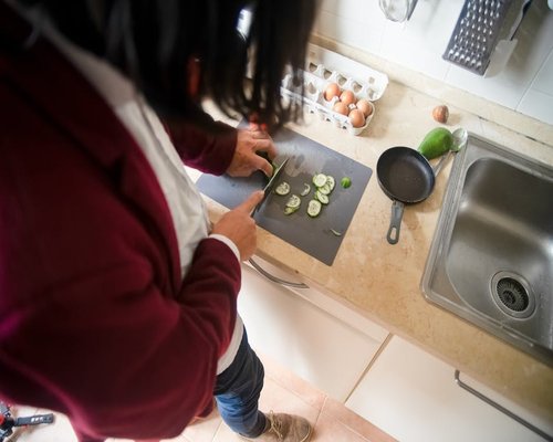 Woman preparing healthy and fresh snacks like cucumber and jicama in her kitchen
